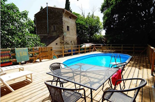 Photo d'un salon de jardin et de transats au bord d'une piscine avec un sol en boit