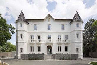 Photo d'un chateau blanc dans son domaine