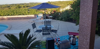 Photo d'un salon de jardin avec un parasol à côté d'une piscine