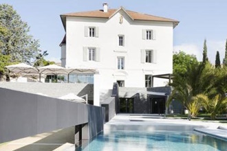 Photo d'un joli bâtiment blanc avec une grande piscine