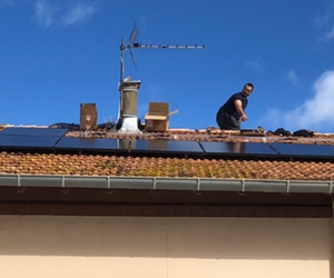 Photo d'une personne sur un toit en train de poser des panneaux photovoltaïques