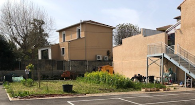 Photo d'un bâtiment et d'une maison à côté du stade de basketball extérieur