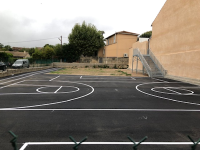 Photo d'un stade de basketball extérieur et nouvellement goudroné et lignes tracées