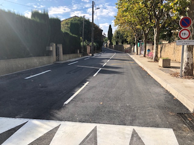 Photo d'une rue nouvelle goudronnée avec un arrêt de bus