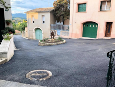 Photo d'une rue nouvellement goudronnée avec un petit rond point