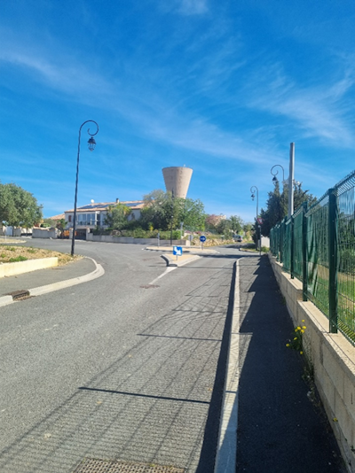 Photo d'un rond point avec un chateau d'eau à l'arrière plan dans le village