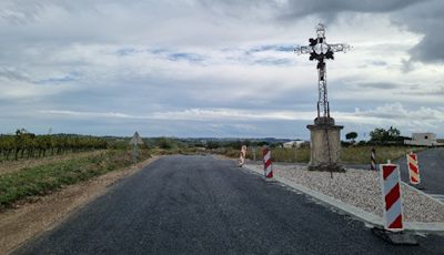 Photo d'une route neuve avec une croix religieuse au milieu